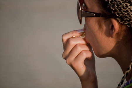 beauty girl eating orange on the gray backgroundの写真素材