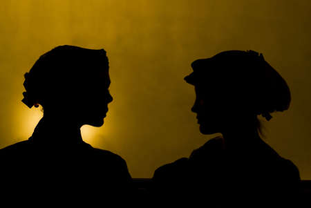 Two beauty silhouette of face to face girlsの写真素材