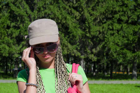 beauty girl in baseball cap looking over sunglasses on the forest backgroundの写真素材