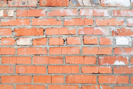 red brick wall with cracks and gray smudges