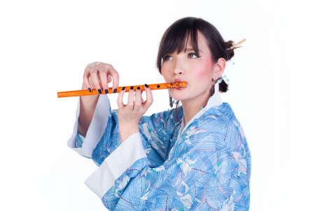 beauty geisha in blue kimono play the flute isolated on white backgroundの写真素材