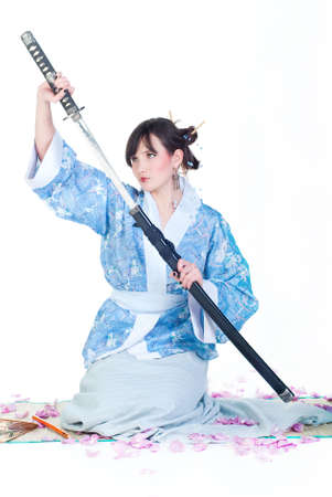 beauty geisha in blue kimono with katana isolated on white backgroundの写真素材