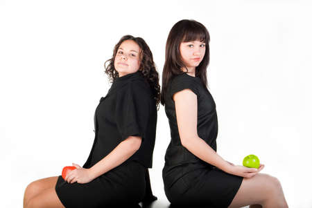 red apple on black wood table between two girl  isolated on white backgroundの写真素材