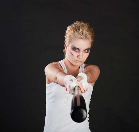 white girl fighter with baseball bat on black backgroundの写真素材