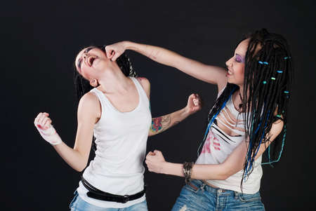white fighting girls with dreads on black background. One girl with body art on her hand.の写真素材