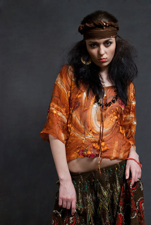 tired young Gypsy woman on the gray backgroundの写真素材