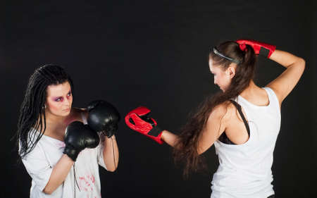 two white girls are boxing with mufflers on black backgroundの写真素材