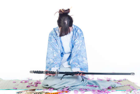 beauty and submissive geisha in blue kimono with katana on white backgroundの写真素材