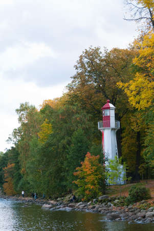 white and red lighthouse on bank of bayの写真素材