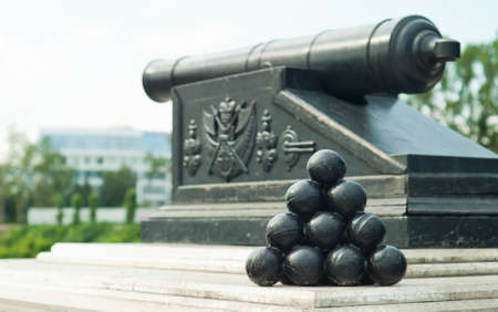 pyramid of cannonballs on the cannon with Omsk state emblem backgroundの写真素材
