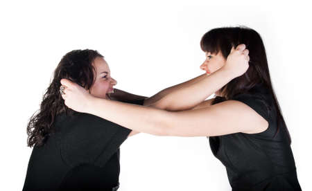 two girls tearing each other hair and scream on white backgroundの写真素材