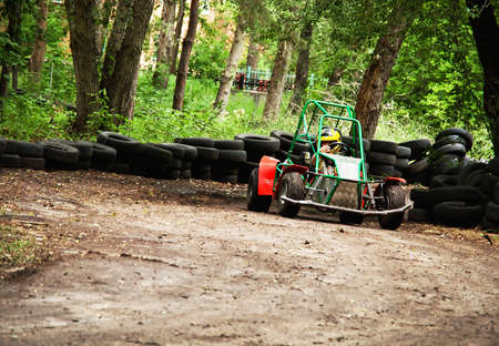homemade buggy on earthen track with barrier of tires on trees backgroundの写真素材