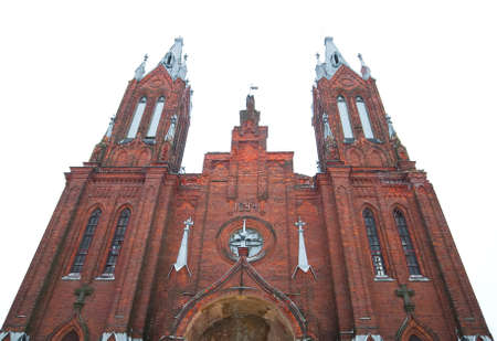 ancient Catholic cathedral of red brick on sky backgroundの写真素材