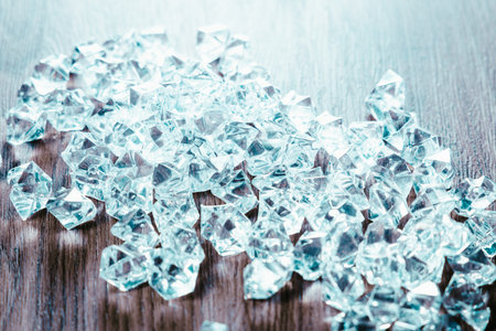 Cubes of ice on wooden table. Shallow depth of field
