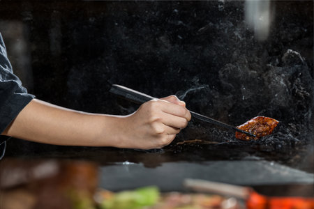 Close-up of chef hand-cooking chicken wing on the barbecue grill.の写真素材