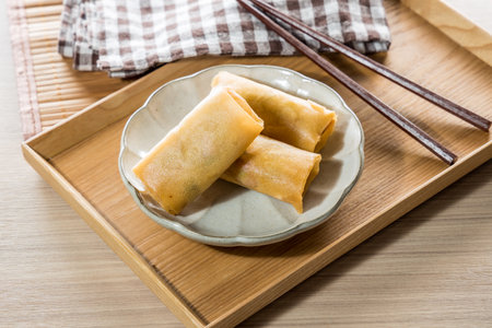 Fried Spring rolls on plate with chopsticks on wooden table.の写真素材
