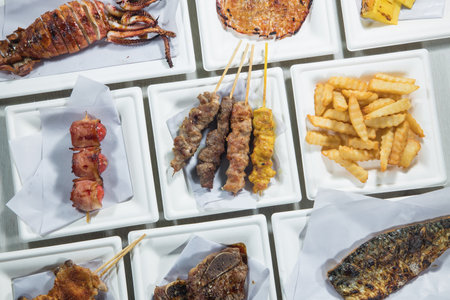 Grilled meat on skewers and French fries in a restaurant.の写真素材