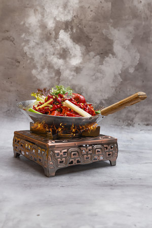 Spicy Crayfish Hot Pot with Sichuan Pepper in a metal bowl on a stone background.の写真素材