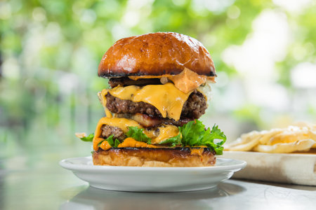 Cheese burger - American cheese burger with Golden French fries on wood tableの写真素材