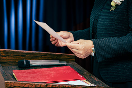A woman in a suit reads a document at the press conference.の写真素材