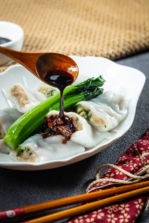 The moment the seasoned sweet soy sauce was poured over the steamed rice rolls with beefの写真素材