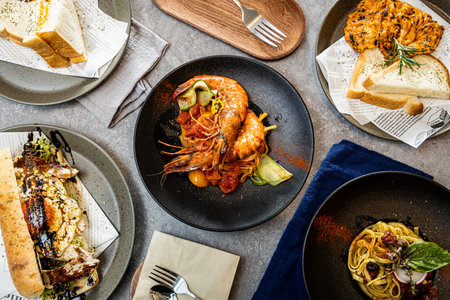 Grilled prawns over pasta with tomato sauce and zucchini, surrounded by gourmet sides like chicken,...