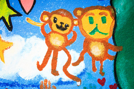 A vibrant mural with two cartoon monkeys, hearts, stars, and clouds on a blue sky background with...
