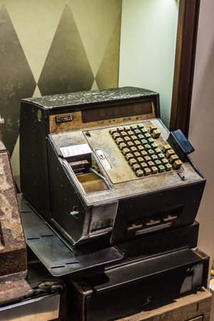 A weathered NCR cash register with mechanical buttons and levers, showcasing historical retail...