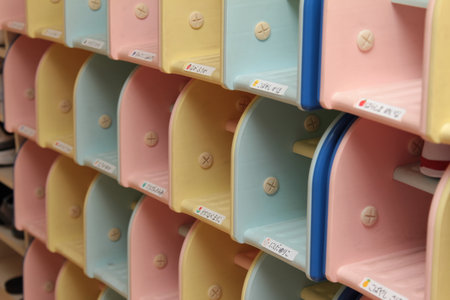 Rows of pastel-colored shoe storage compartments arranged neatly with visible labelsの写真素材