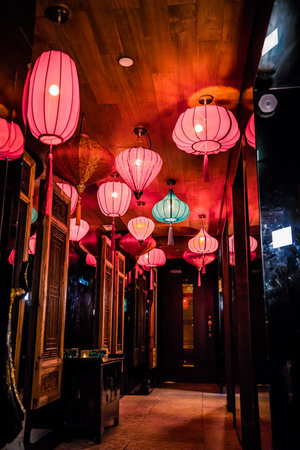 A narrow hallway filled with colorful lanterns and carved wood panels, creating a festive and ornate ambiance.の写真素材