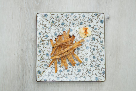 Juicy grilled beef short ribs served on a slate plate surrounded by fresh vegetables and lime slices.の写真素材