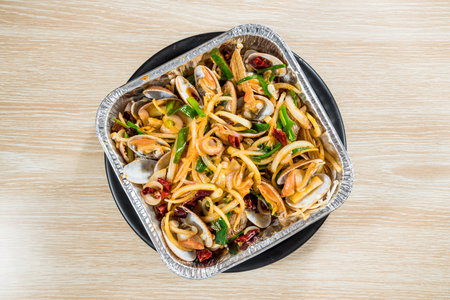 Clams stir fried with chili basil and garlic served in a tray. The vibrant presentation highlights...
