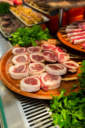 Meat department, showcase with variety of meat in different cuts. Inside an supermarket. Different types of fresh meat arranged in an orderly mannerの写真素材