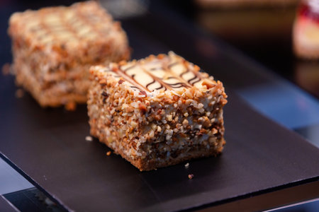 Cake with cream and nuts on a black plate. close upの素材