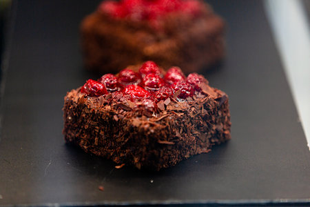 Chocolate cake with raspberries and chocolate on a black plateの素材