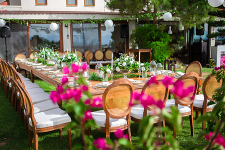 Outdoor restaurant with chairs and table set for wedding dinner in summerの素材