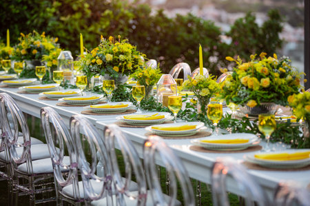 Wedding table decoration with yellow flowers and candles in restaurant.の素材