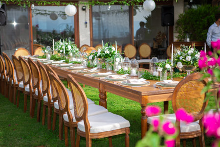 Wedding table setting with chairs and tableware in the gardenの素材