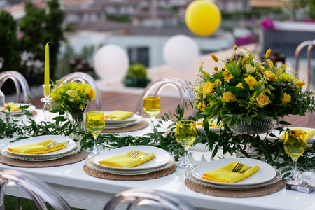Wedding table setting with yellow napkins, glasses and platesの素材