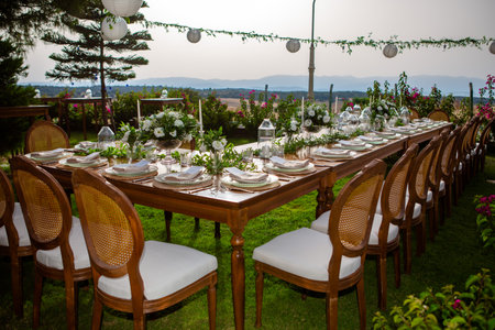 Wedding table setting with chairs and tablecloth in the gardenの素材