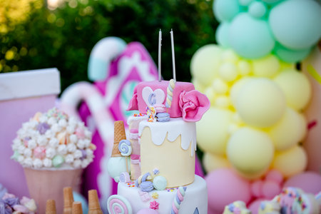 Colorful birthday cake with ice cream and balloons, selective focus.の素材