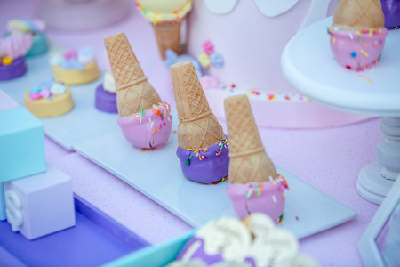 Ice cream in waffle cones on a table at a birthday partyの素材