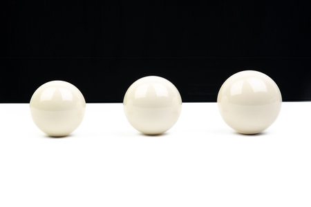 Three white balls on a black and white background. isolated.の素材