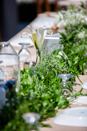 Wedding table decoration with flowers and greenery in a restaurantの素材