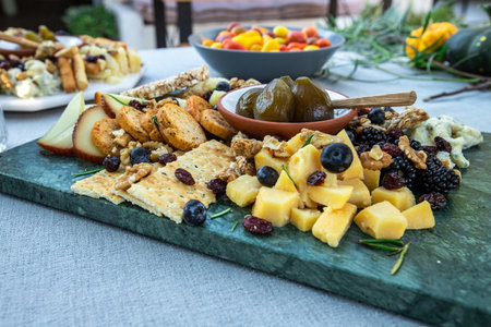Cheese plate with crackers, olives and fruits.の素材