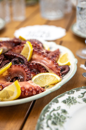 Fresh octopus with lemon slices on a plate. Selective focus.