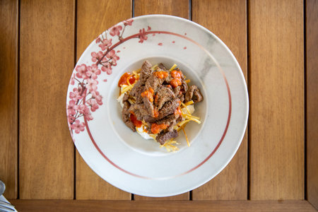 Beef Stroganoff with egg and tomato sauce on white plate
