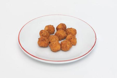 Fried chicken nuggets on a plate isolated on white background.