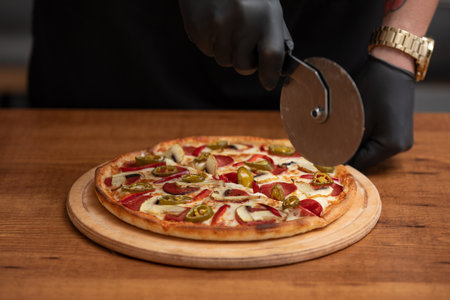 Chef cutting pizza on the tableの写真素材