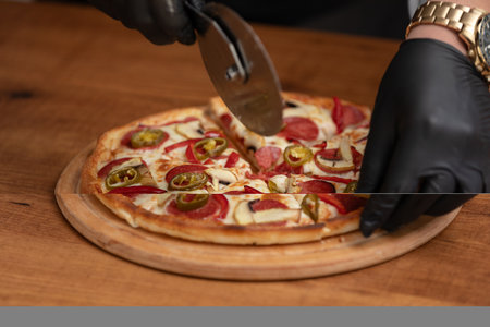 Chef cutting pizza on the tableの写真素材